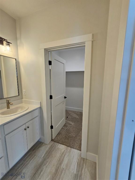 bathroom with vanity, baseboards, and wood finished floors