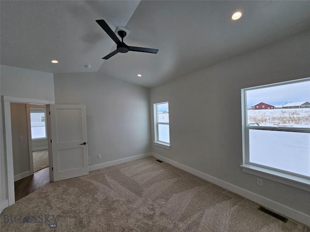 unfurnished bedroom featuring lofted ceiling, recessed lighting, visible vents, carpet flooring, and baseboards