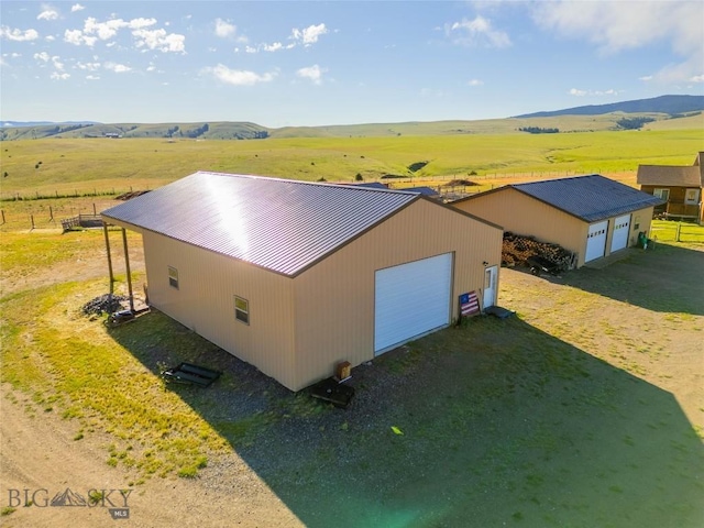 drone / aerial view featuring a mountain view and a rural view