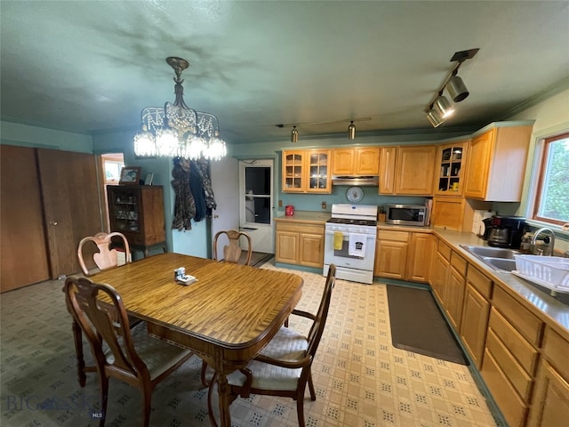 kitchen with rail lighting, white range, sink, pendant lighting, and a chandelier