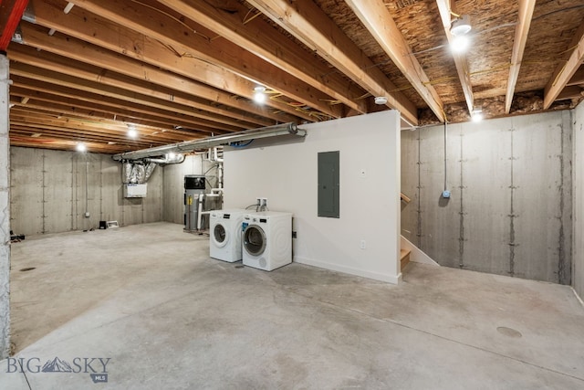 basement with hybrid water heater, electric panel, and washer and dryer