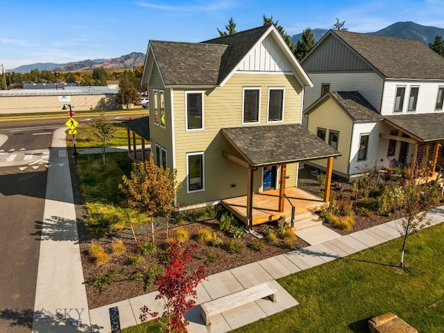 view of front facade with a mountain view, covered porch, and a front lawn