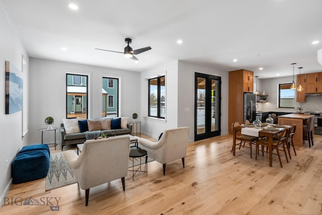 living room featuring french doors, ceiling fan, and light hardwood / wood-style flooring