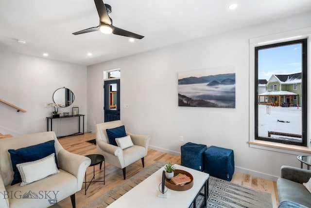 living room with ceiling fan, a healthy amount of sunlight, and light hardwood / wood-style flooring