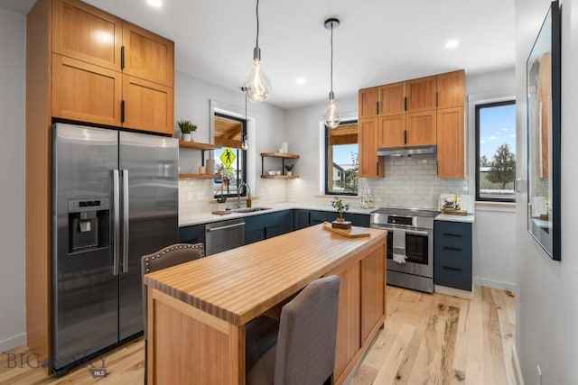 kitchen featuring a kitchen island, pendant lighting, sink, a breakfast bar area, and stainless steel appliances