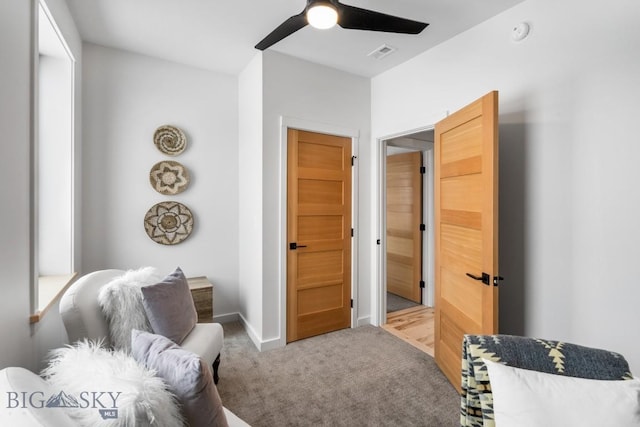 living area featuring ceiling fan and light colored carpet