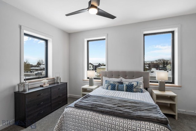 bedroom featuring multiple windows, ceiling fan, and dark colored carpet