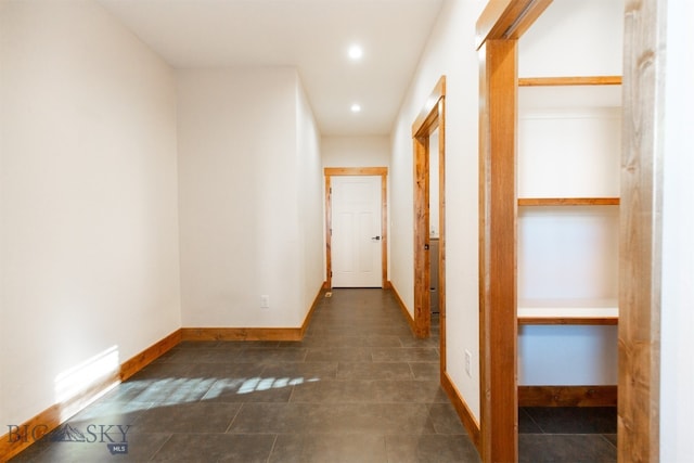 hall featuring dark tile patterned flooring