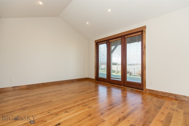 unfurnished room featuring light wood-type flooring and lofted ceiling