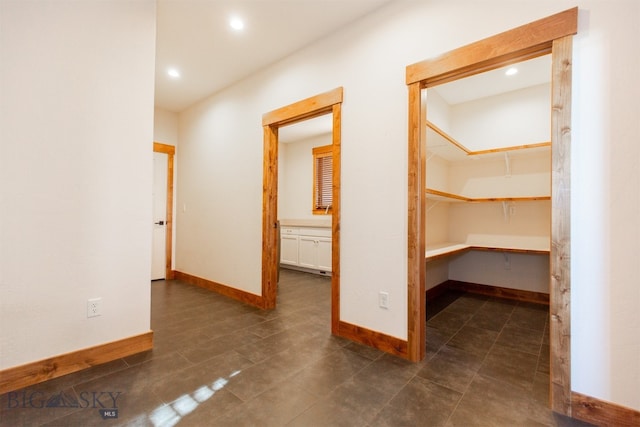 hallway featuring dark tile patterned floors