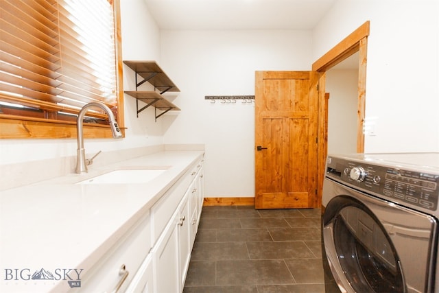 laundry room featuring washer / clothes dryer, sink, cabinets, and dark tile patterned flooring