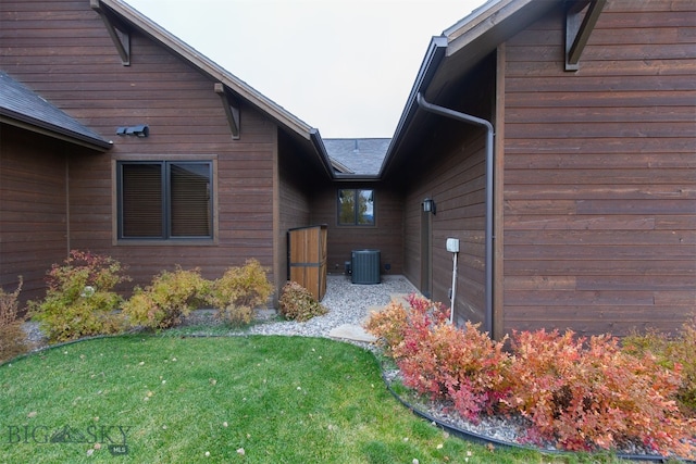 view of home's exterior featuring central air condition unit and a lawn