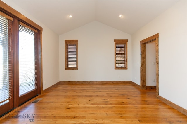 empty room featuring lofted ceiling and light wood-type flooring