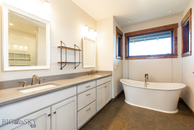 bathroom featuring a washtub and vanity