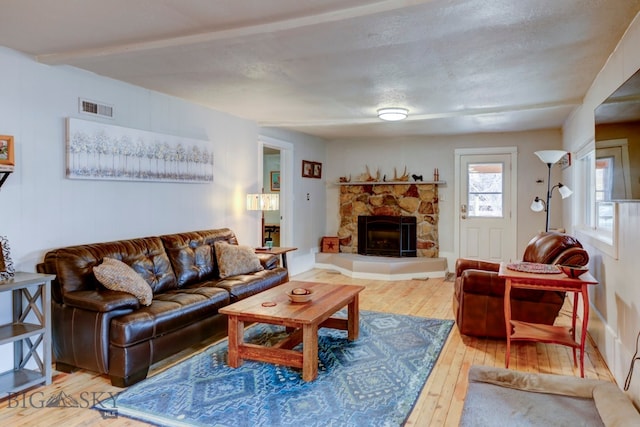 living room with hardwood / wood-style floors, a fireplace, and a textured ceiling