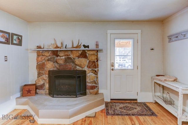 interior space with light hardwood / wood-style floors and a stone fireplace