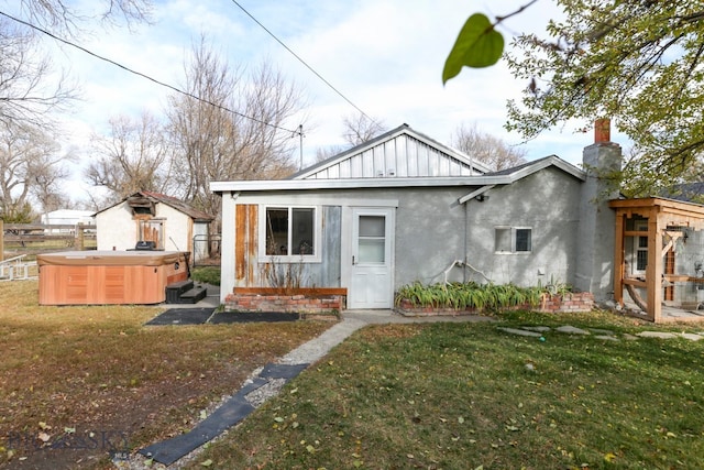 view of front of property with a hot tub and a front lawn