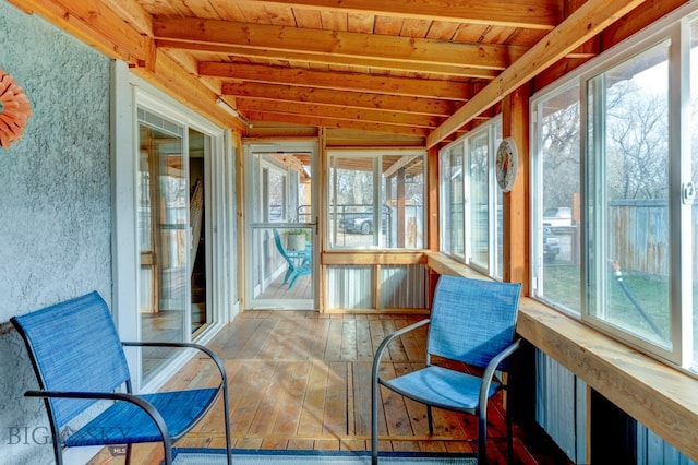 sunroom with vaulted ceiling with beams, plenty of natural light, and wooden ceiling