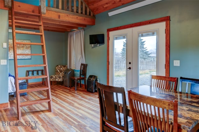 dining area featuring french doors, light hardwood / wood-style floors, and lofted ceiling