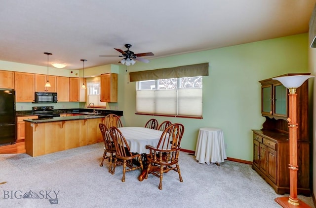 dining area featuring ceiling fan, light colored carpet, and sink