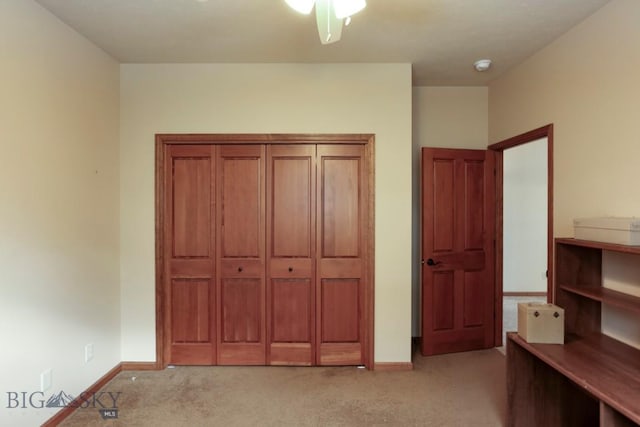 unfurnished bedroom featuring ceiling fan, light colored carpet, and a closet