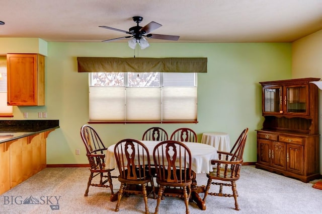 carpeted dining area with ceiling fan