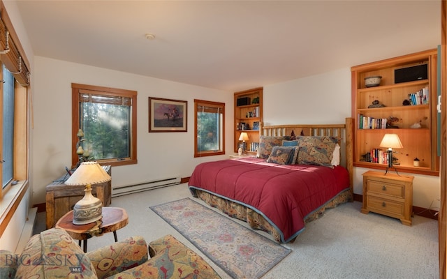 bedroom with baseboard heating, multiple windows, and light colored carpet