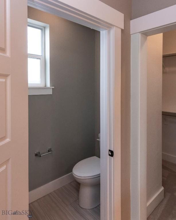 bathroom featuring toilet and baseboards