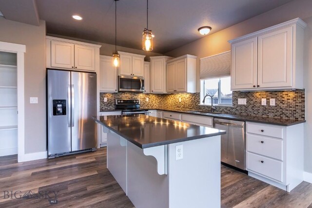 kitchen featuring a kitchen island, white cabinetry, sink, and appliances with stainless steel finishes