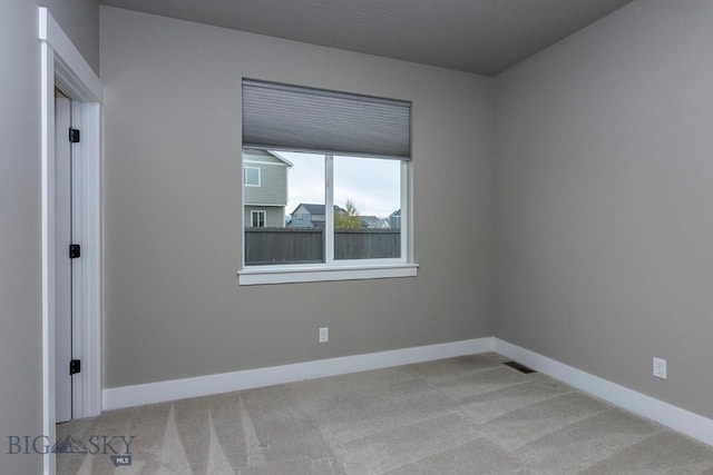 spare room with visible vents, baseboards, and carpet flooring