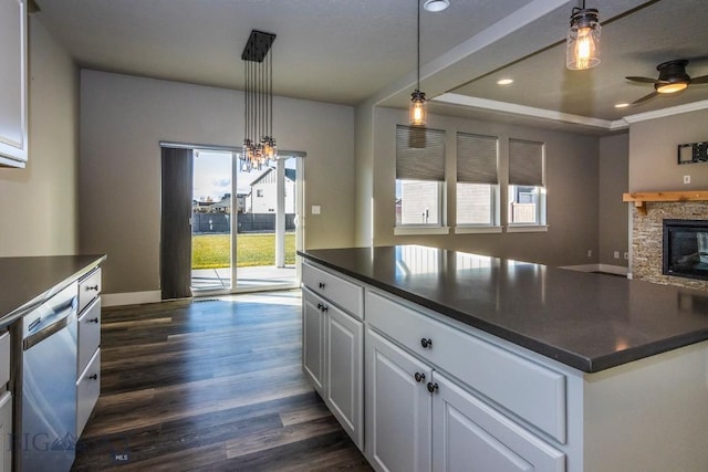 kitchen with white cabinetry, stainless steel dishwasher, dark countertops, and ceiling fan