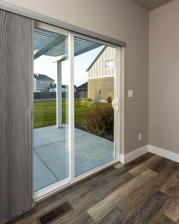 doorway featuring wood finished floors, baseboards, and visible vents