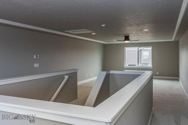 hall featuring crown molding, carpet, a textured ceiling, an upstairs landing, and baseboards