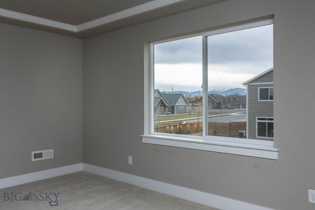 carpeted spare room featuring visible vents, baseboards, and a mountain view