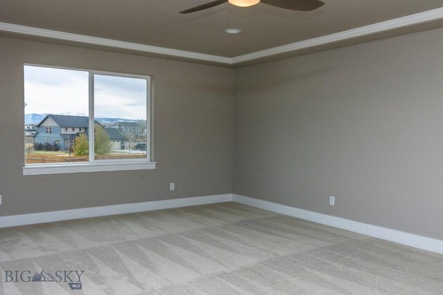 carpeted empty room with ceiling fan and ornamental molding