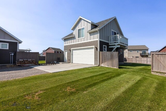 exterior space featuring a yard, a balcony, a patio, and a garage