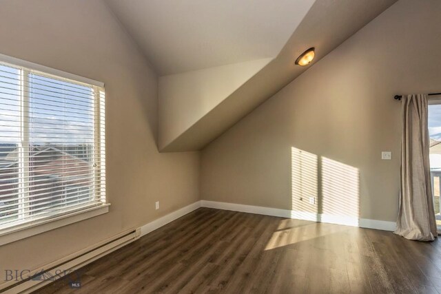 additional living space featuring dark hardwood / wood-style flooring, a baseboard radiator, and vaulted ceiling