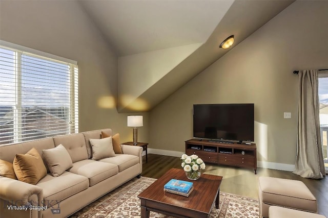 living area featuring baseboards, vaulted ceiling, and wood finished floors