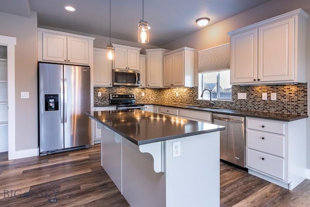 2133 Stewart Loop, Bozeman, MT 59718 - kitchen with appliances with stainless steel finishes, dark countertops, dark wood-style floors, a center island, and white cabinetry