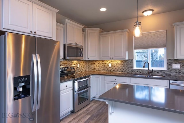 2133 Stewart Loop, Bozeman, MT 59718 - kitchen with stainless steel appliances, dark countertops, backsplash, white cabinets, and recessed lighting