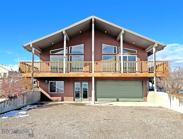 rear view of house featuring a garage and a deck