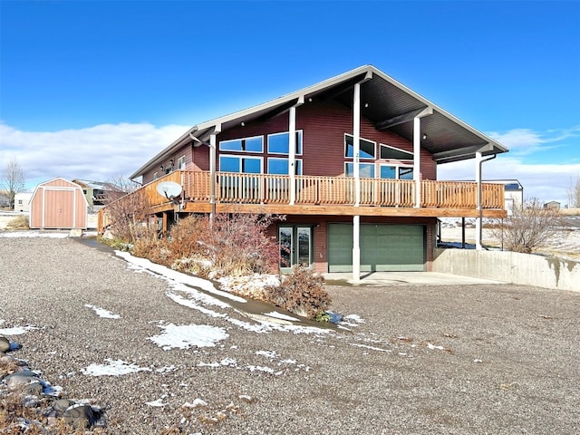 view of front facade featuring a storage unit, a garage, and a wooden deck