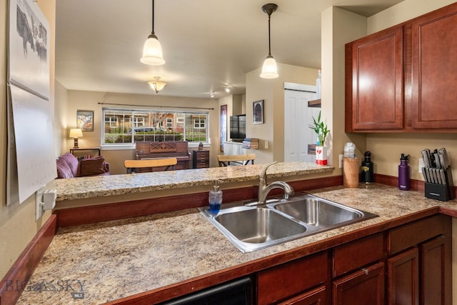 kitchen featuring decorative light fixtures, kitchen peninsula, and sink