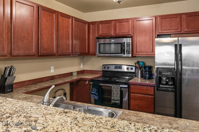 kitchen featuring light stone countertops, sink, and appliances with stainless steel finishes