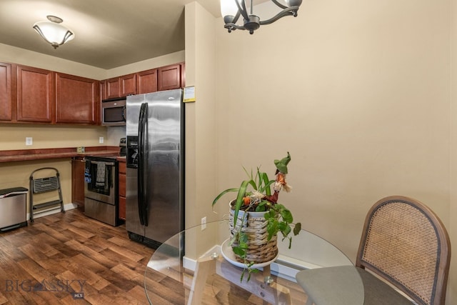 kitchen featuring a chandelier, appliances with stainless steel finishes, and dark wood-type flooring