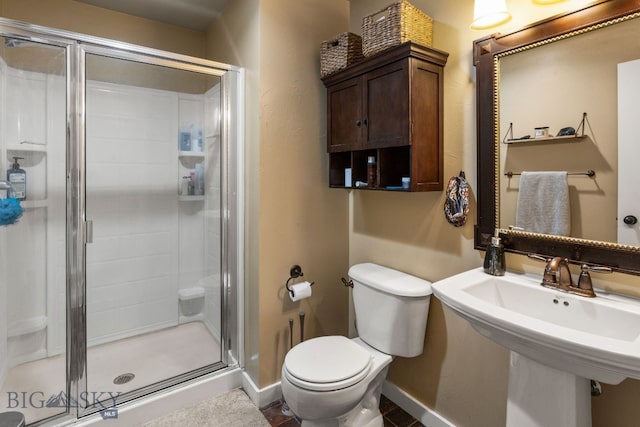 bathroom featuring walk in shower, sink, and toilet