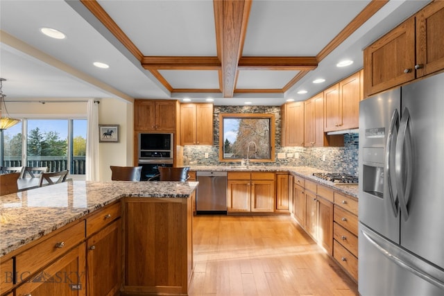 kitchen with ornamental molding, pendant lighting, stainless steel appliances, and light hardwood / wood-style floors