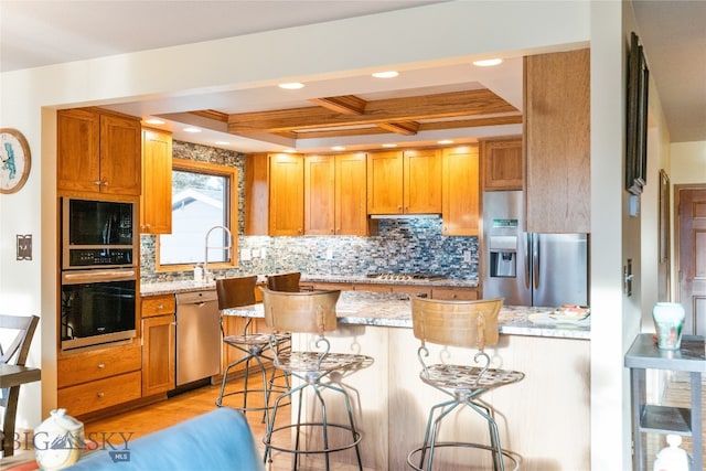 kitchen with a breakfast bar, light stone countertops, tasteful backsplash, beam ceiling, and stainless steel appliances