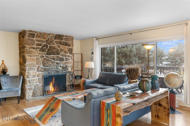 living room featuring a stone fireplace and hardwood / wood-style floors