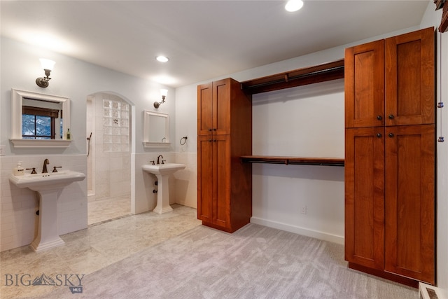 bathroom featuring tile patterned floors, a shower, and tile walls